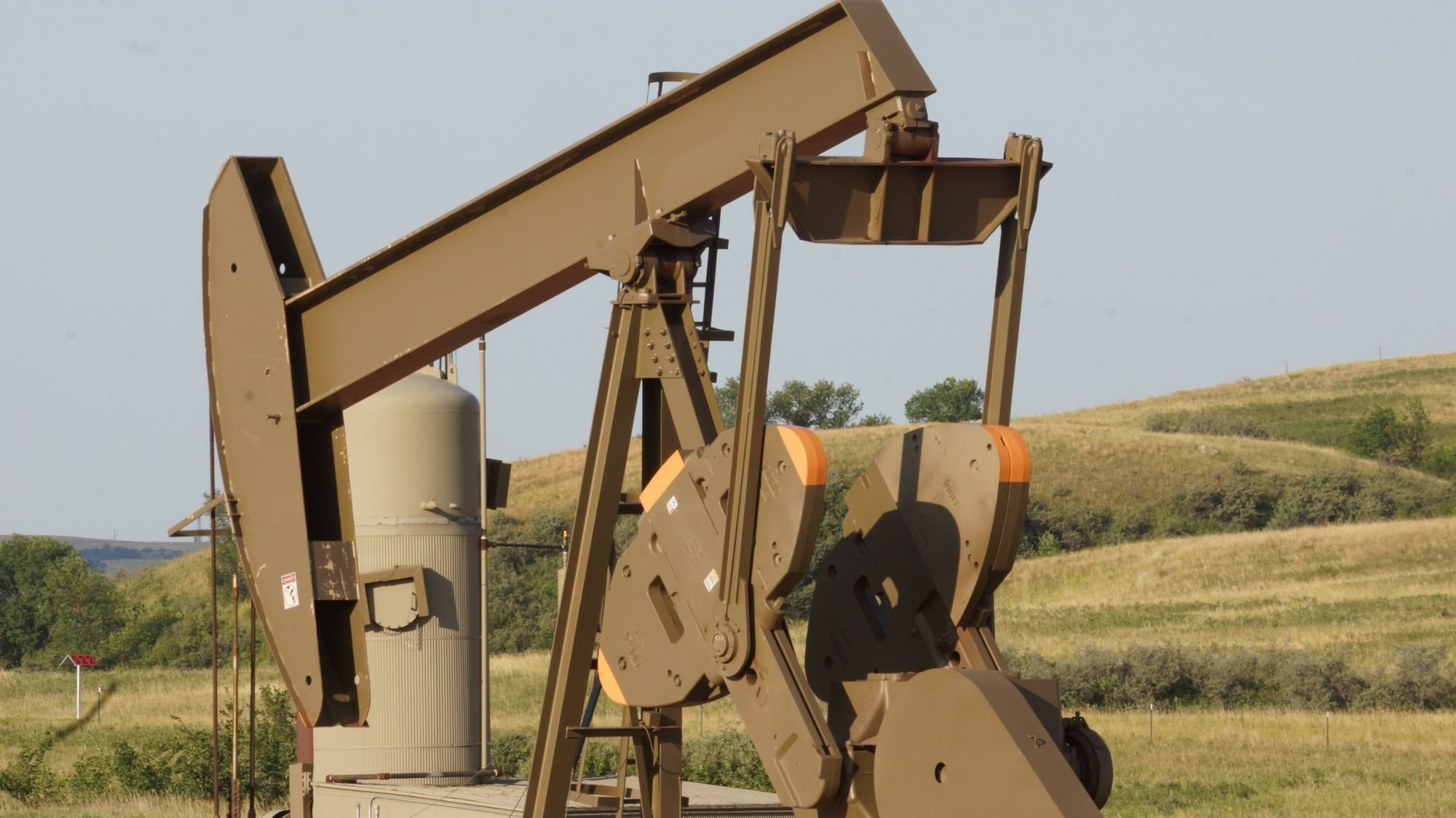 Close-up of a pumping unit in rolling grassland
