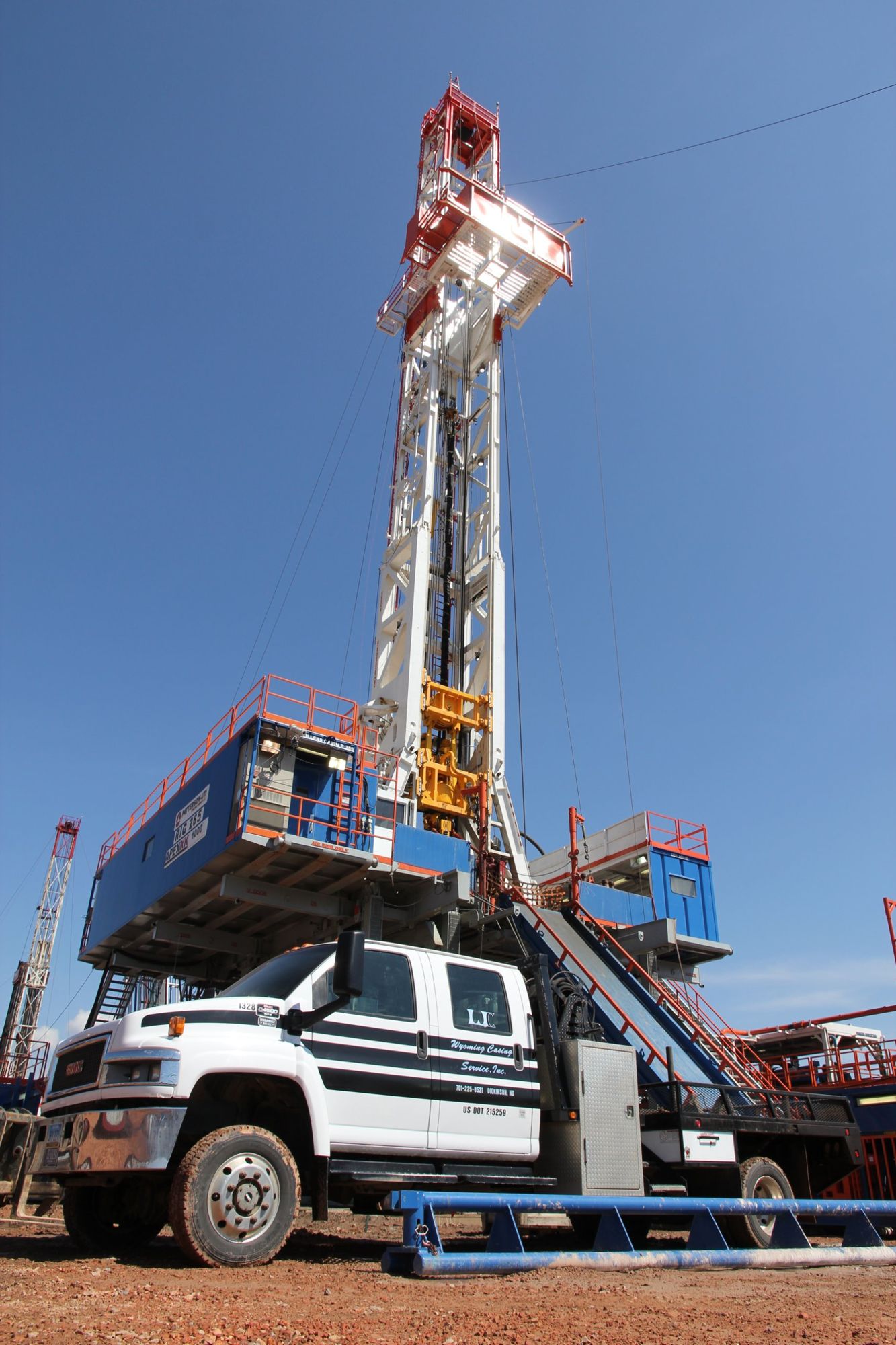 Service truck parked beneath a drilling rig